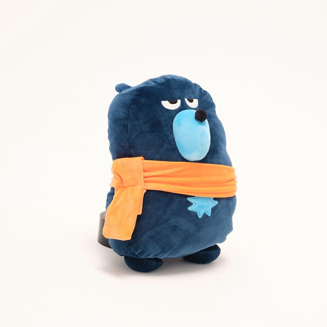 Blue plush toy with an orange bandana on a white background