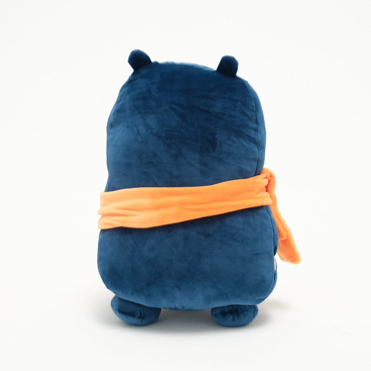 Blue plush toy with an orange bandana on a white background